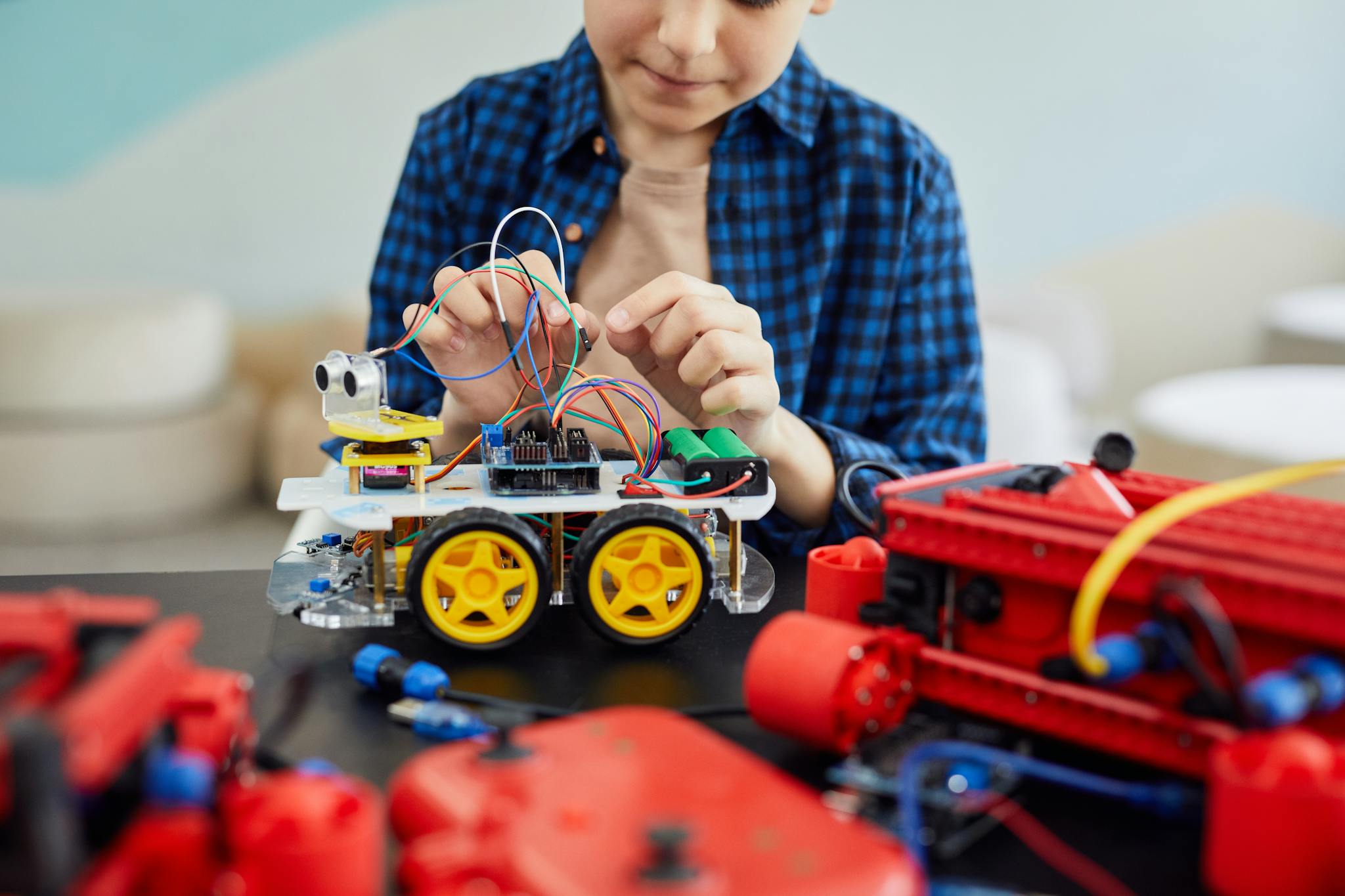 Young boy engaged in assembling a robotic toy car, showcasing early interest in STEM education.